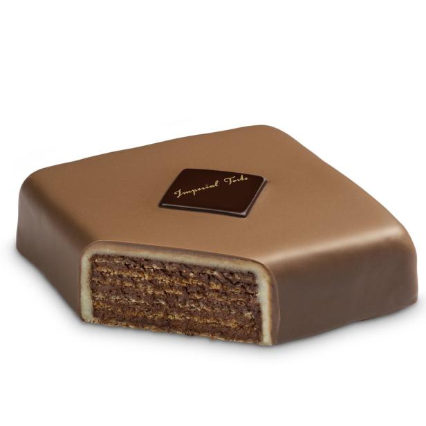 Ein angeschnittenes Stück Imperial Torte mit Schokoladenglasur und Waffelschichten.