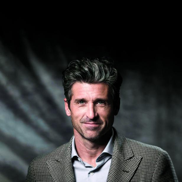 Porträt von Patrick Dempsey mit grau meliertem Haar und kariertem Sakko.