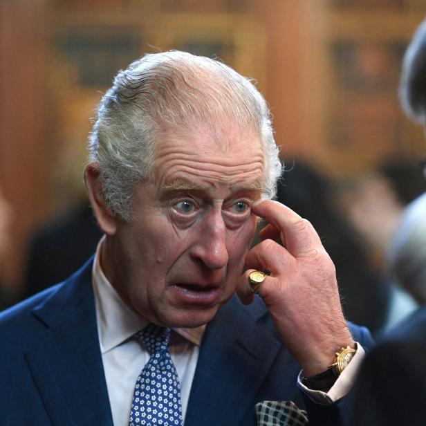 König Charles III. berührt sein Auge.