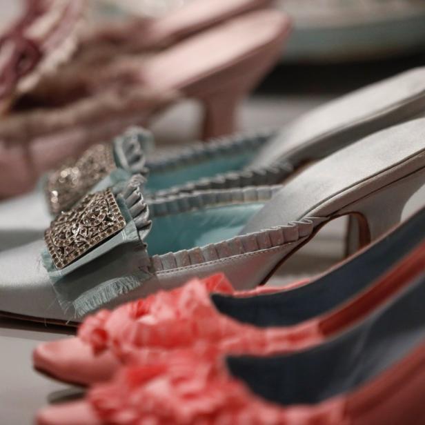 Eine Reihe von historischen Schuhen in Pastellfarben mit Verzierungen.