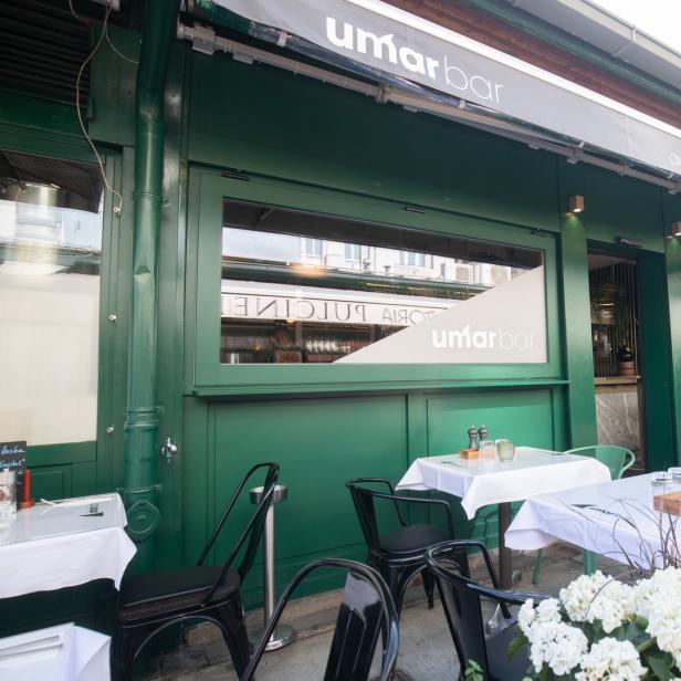 Außenansicht der Umar Bar mit Tischen und Stühlen auf dem Bürgersteig.