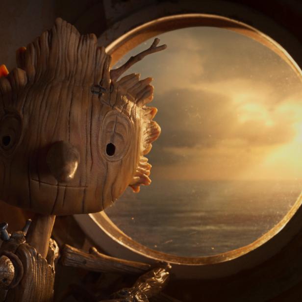 Pinocchio blickt aus einem Bullauge auf das Meer bei Sonnenuntergang.