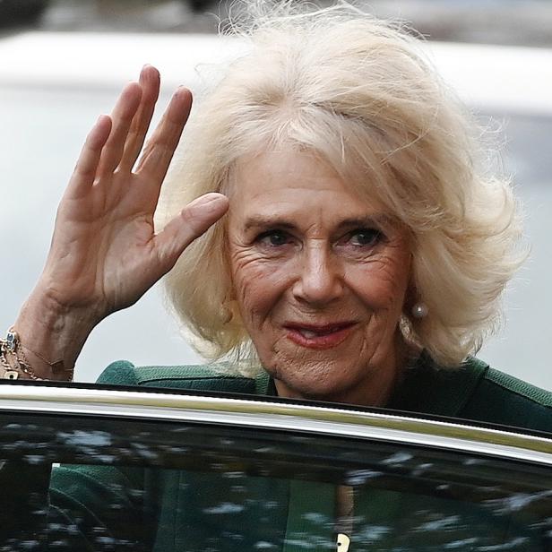 Königsgemahlin Camilla winkt aus einem Auto.