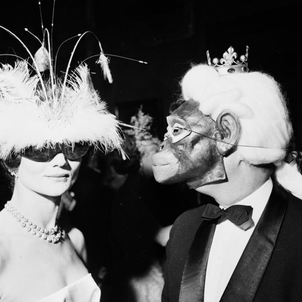 Zwei Personen in Kostümen und Masken auf einer Party.