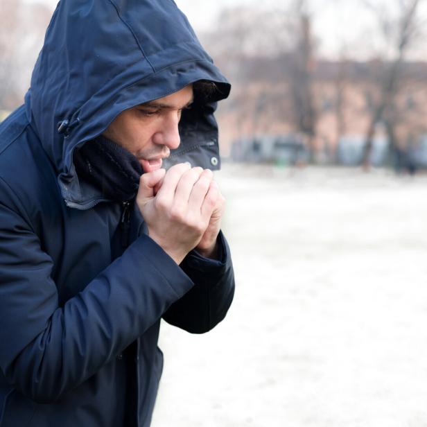 Man dressed in warm clothing in snowy weather