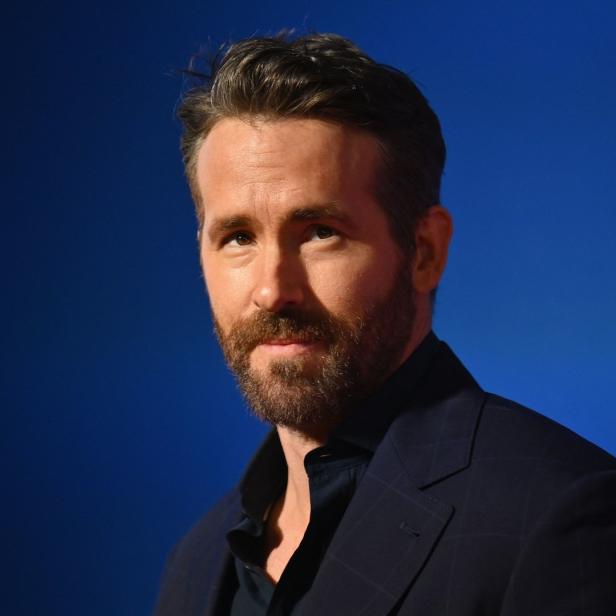 Porträt von Ryan Reynolds vor einem blauen Hintergrund.