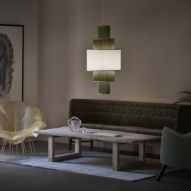 Ein Wohnzimmer mit einem Sofa, einem Tisch und einer ungewöhnlichen Lampe.