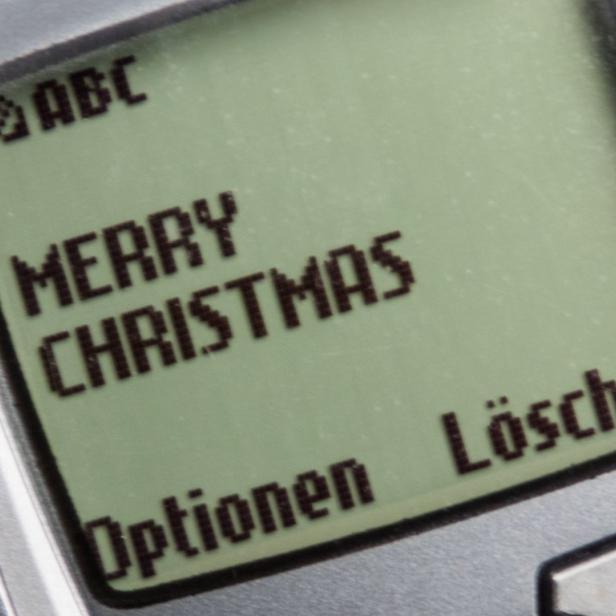 Ein altes Handy zeigt die Nachricht „Merry Christmas“ auf dem Display.