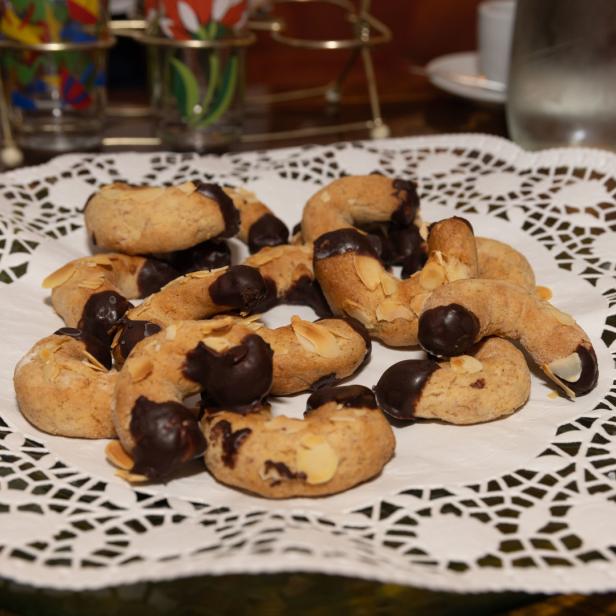 Eine Platte mit Vanillekipferl, teilweise mit Schokolade überzogen.