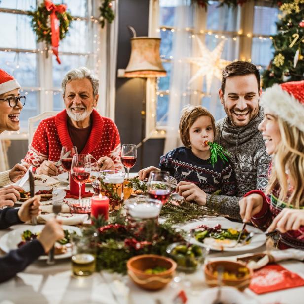 Eine Familie feiert Weihnachten und isst gemeinsam am Tisch.