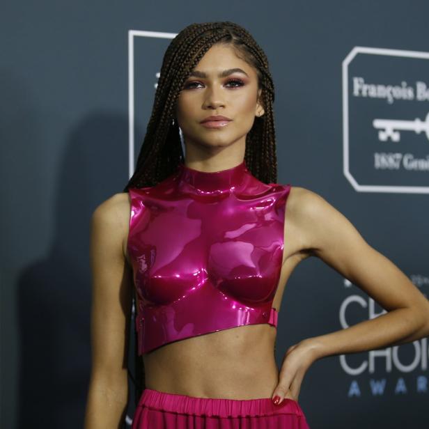 Zendaya posiert in einem pinkfarbenen Outfit auf dem roten Teppich.