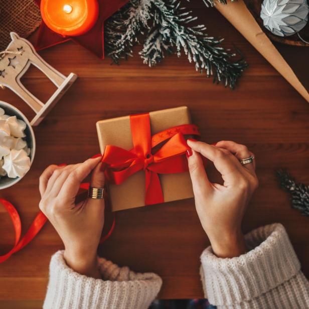 Eine Frau verpackt Weihnachtsgeschenke, Draufsicht.