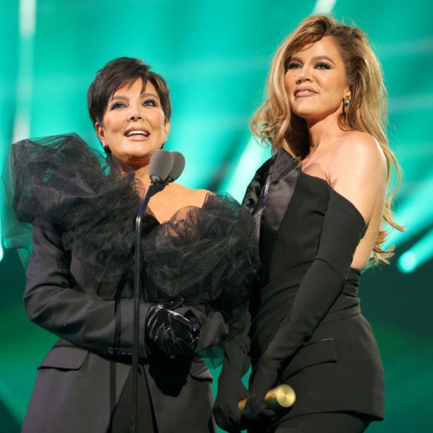 Kris Jenner und Khloé Kardashian stehen auf einer Bühne vor grünem Hintergrund.