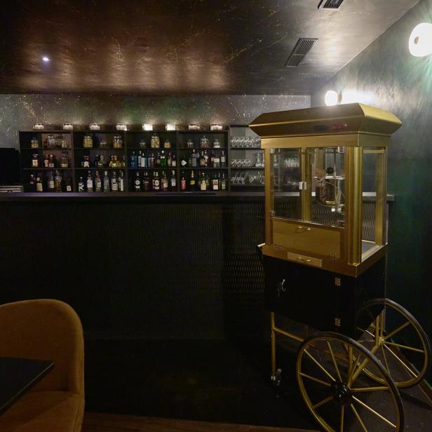 Eine Bar mit einer goldenen Popcornmaschine auf Rädern.