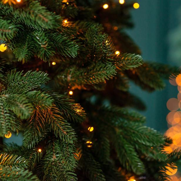 Nahaufnahme eines Weihnachtsbaums mit warmen Lichtern.