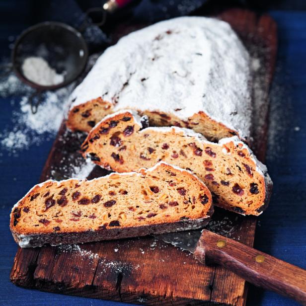 Ein angeschnittener Stollen liegt auf einem Holzbrett.