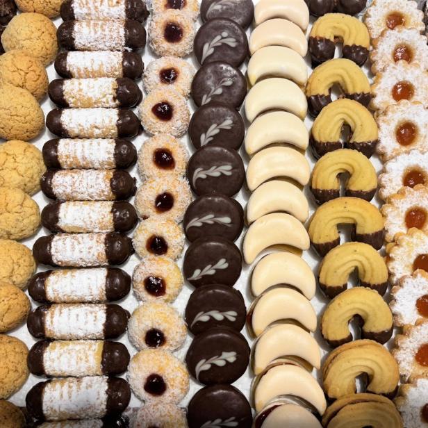 Eine Auswahl verschiedener Weihnachtsplätzchen, darunter Vanillekipferl, Schokocrossies und Linzer Augen.