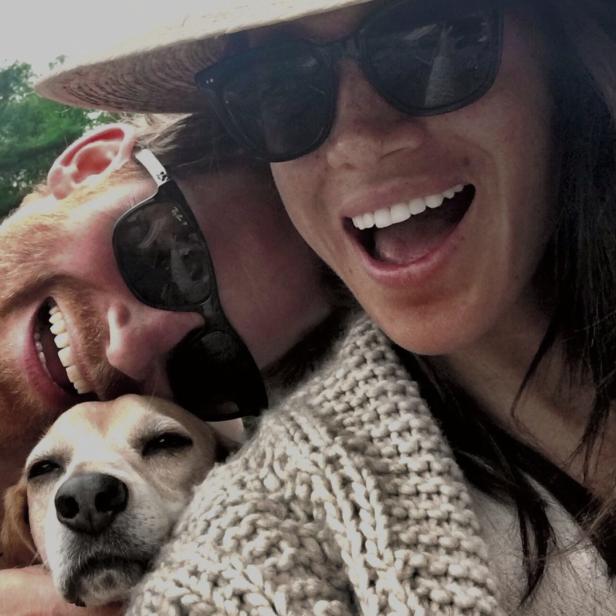 Prinz Harry, Meghan Markle und ihr Hund posieren lächelnd für ein Selfie.