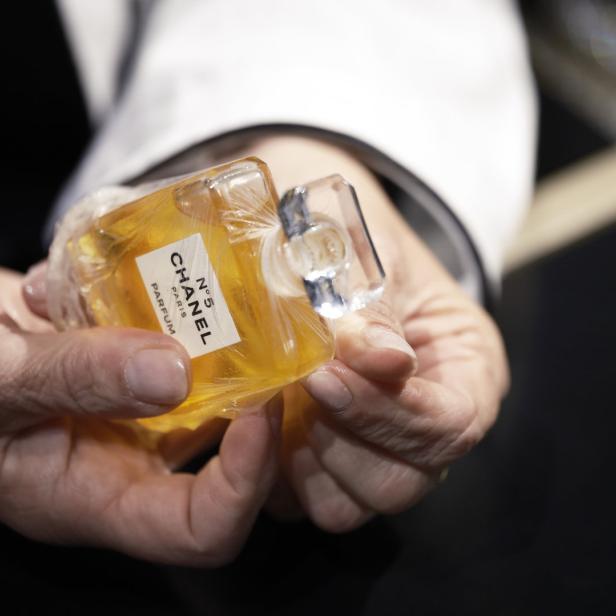 Eine Person hält eine Flasche Chanel N°5 Parfum in den Händen.
