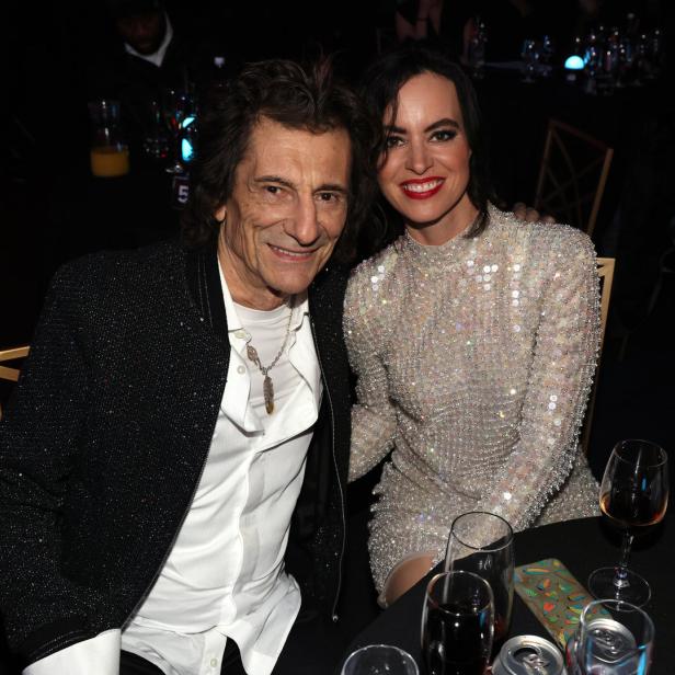 Ronnie Wood und Sally Humphreys posieren zusammen an einem Tisch.