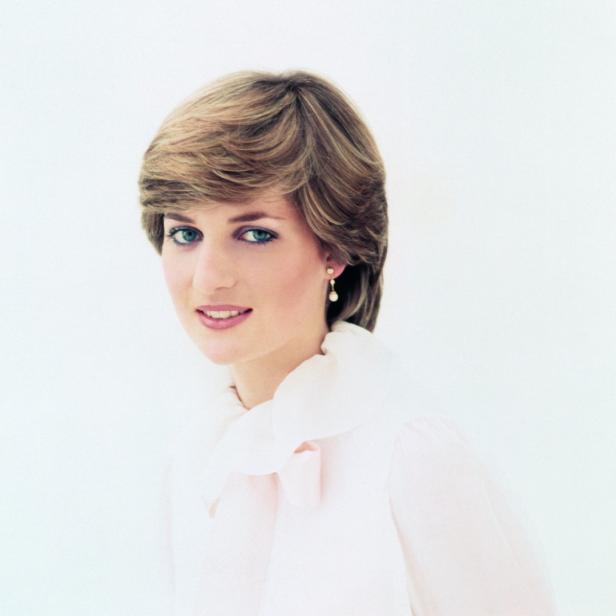 Ein Porträt von Prinzessin Diana mit blondem Haar und einem hellrosa Oberteil vor einem weißen Hintergrund.