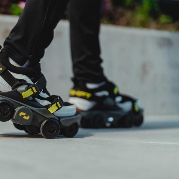 Nahaufnahme von Schuhen mit Rollen an den Füßen einer Person.