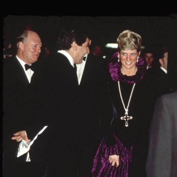 Diana, Prinzessin von Wales, in einer violetten Robe mit Kreuzkette bei einer Veranstaltung.