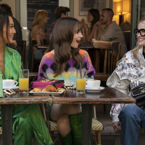 Drei Frauen sitzen in einem Café in Paris bei Kaffee und Croissants.