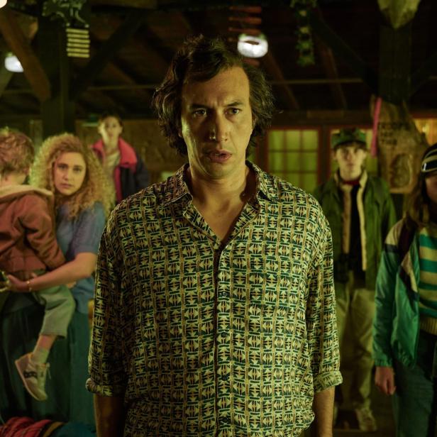 Adam Driver steht mit anderen Darstellern in einer Szene aus dem Film „White Noise“.