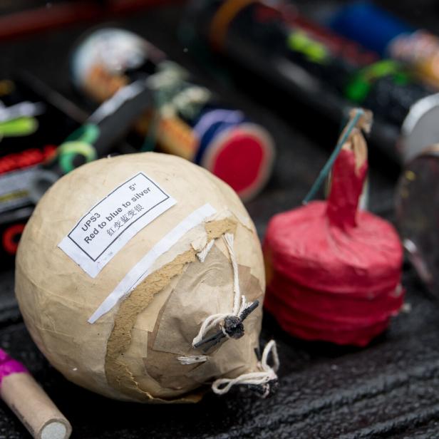 Verschiedene Feuerwerkskörper liegen auf einer dunklen Oberfläche.