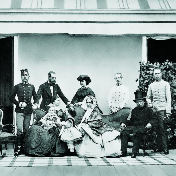 Eine formelle Gruppenaufnahme einer Familie im Freien, vermutlich aus dem 19. Jahrhundert.