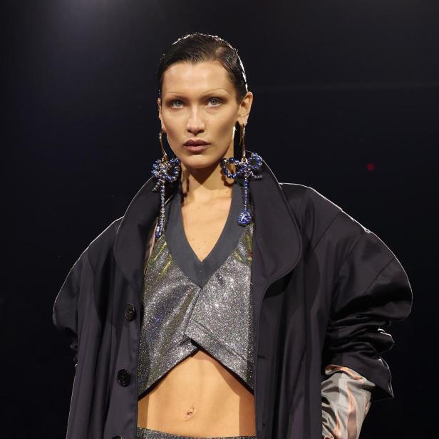 Bella Hadid trägt ein glitzerndes Outfit und auffällige Ohrringe auf dem Laufsteg.