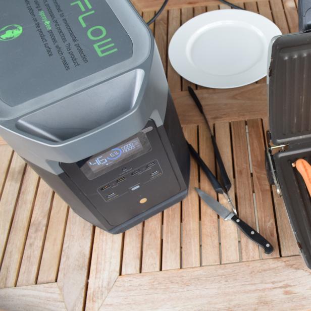 Die Ecoflow Delta Max Powerstation verbunden mit einem Tischgriller auf dem Balkon.