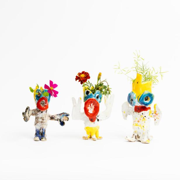 Drei bunte, handgefertigte Keramikfiguren mit Blumen auf einem weißen Hintergrund.
