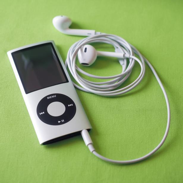 Ein silberner iPod mit weißen Kopfhörern auf einem grünen Hintergrund.