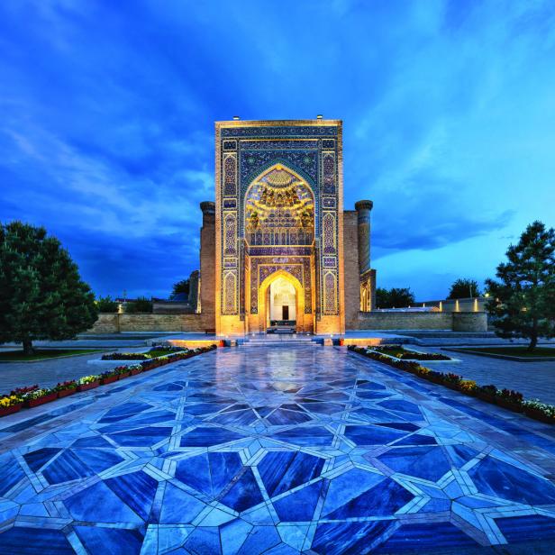 Der kunstvoll verzierte Eingangsbereich einer Moschee in Samarkand bei Dämmerung.