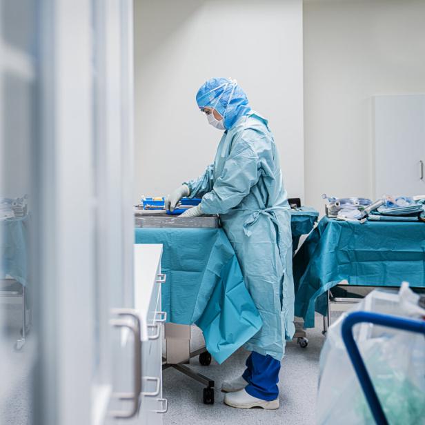 Eine Frau in OP-Kleidung bereitet Instrumente für eine Operation vor.
