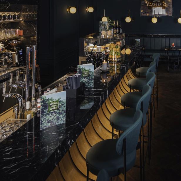 Innenansicht des Restaurants „Maria und Josef“ mit Bar und Sitzplätzen.
