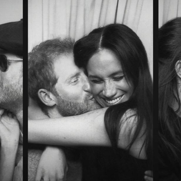 Ein Schwarzweißfoto von Prinz Harry, der Meghan Markle auf die Wange küsst, während sie lächelt.