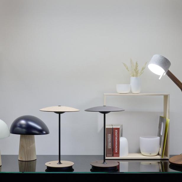 Verschiedene moderne Lampen stehen auf einem Tisch und hängen an der Wand.