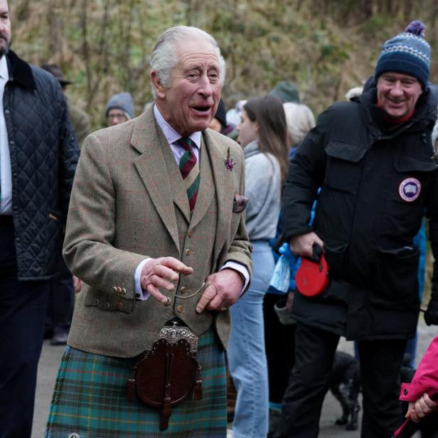 König Charles III. im Kilt mit Hunden bei einem öffentlichen Auftritt.