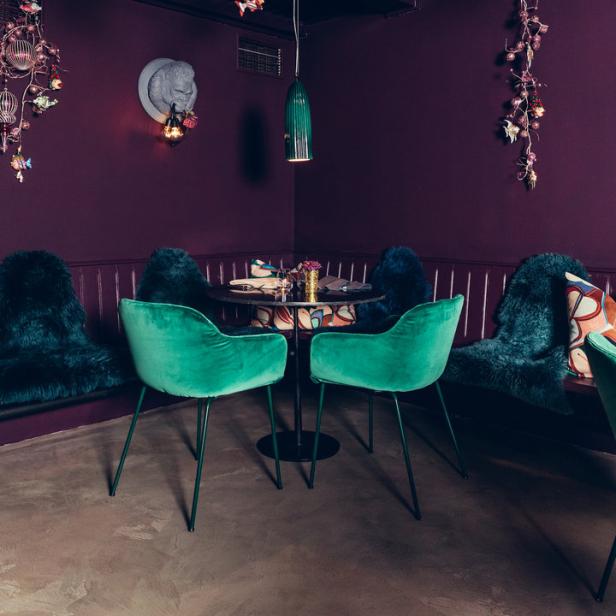 Ein Speisezimmer in Lila und Grün mit ungewöhnlicher Dekoration.