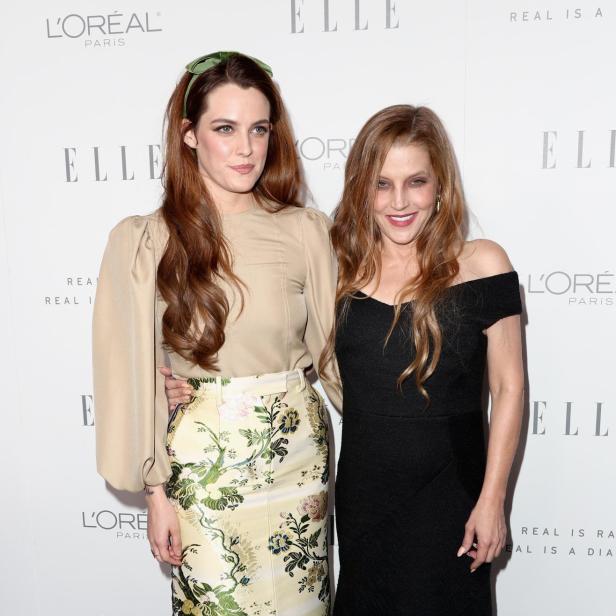 Riley Keough und Lisa Marie Presley posieren zusammen vor einer „Elle“-Werbewand.