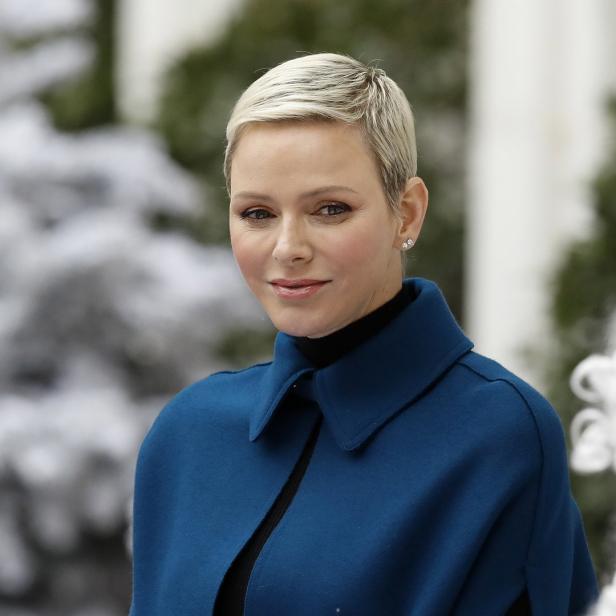 Fürstin Charlène von Monaco mit kurzem blonden Haar und blauem Mantel.