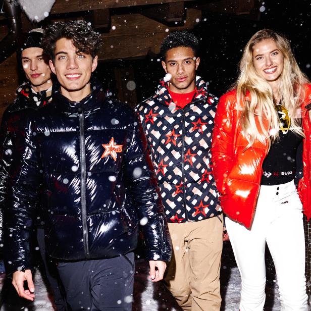 Vier Personen tragen Winterjacken von BOSS im Schnee.
