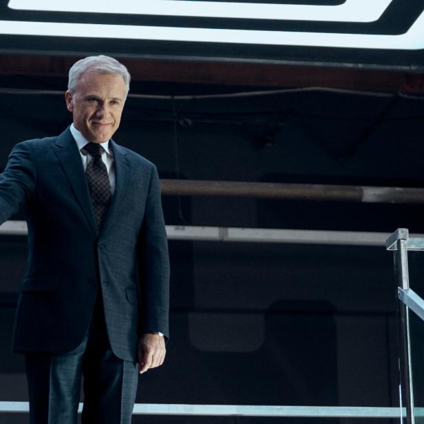Christoph Waltz in einem dunklen Anzug lächelt.