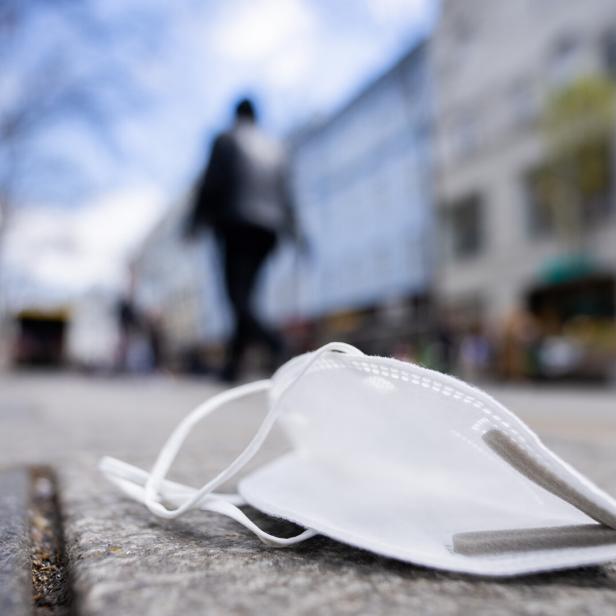Eine FFP2-Maske liegt auf einer Straße.