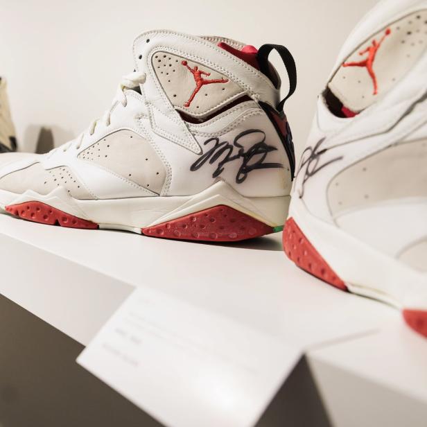 Eine Reihe von signierten Air Jordan Sneakern auf einem Regal in einer Ausstellung.