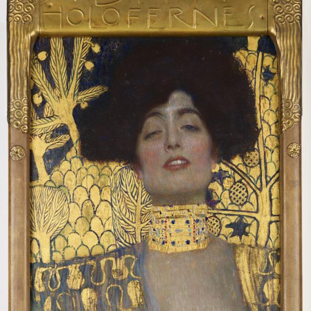 Das Gemälde „Judith I“ von Gustav Klimt zeigt eine Frau mit dunklem Haar und goldenem Schmuck vor goldenem Hintergrund.
