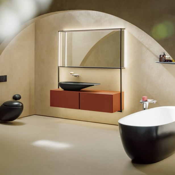 Ein modernes Badezimmer mit freistehender Badewanne, Waschtisch und Toilette in einem gewölbeartigen Raum.